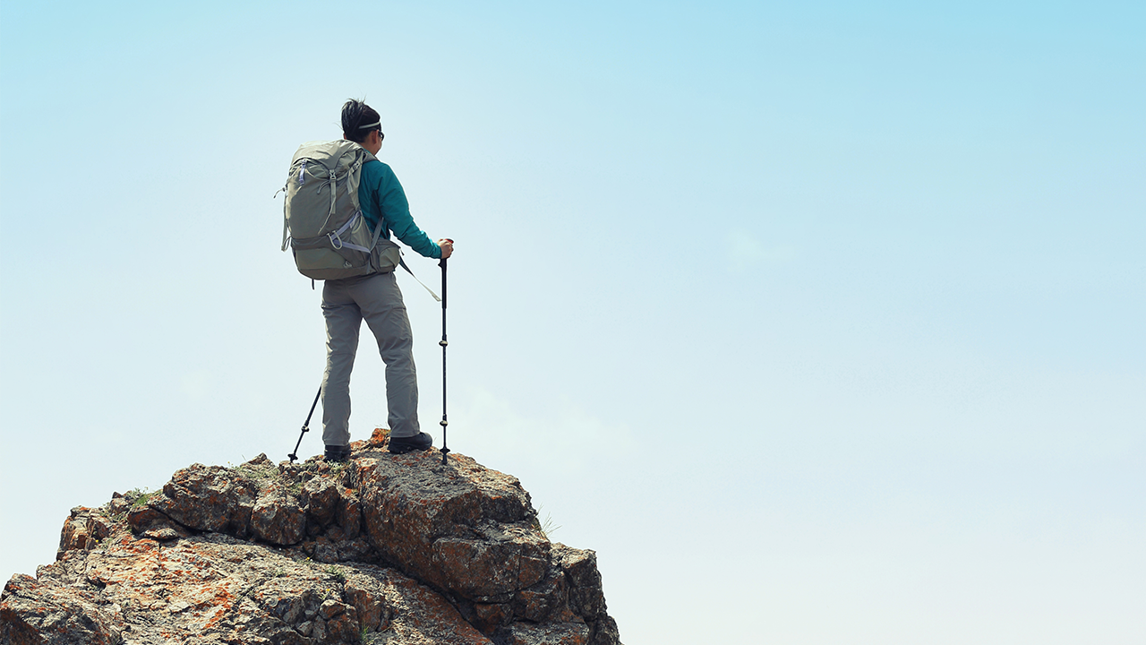image of a hiker standing at the top of a mountain