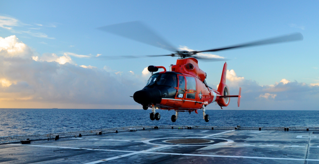 Image of a man being lowered out of a helicopter in the air