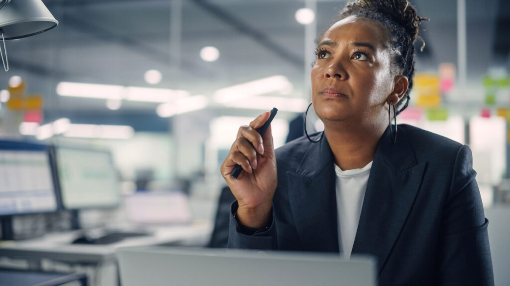 Woman executive contemplating a decision, symbolizing the need for real-time event intelligence to power financial decisions.