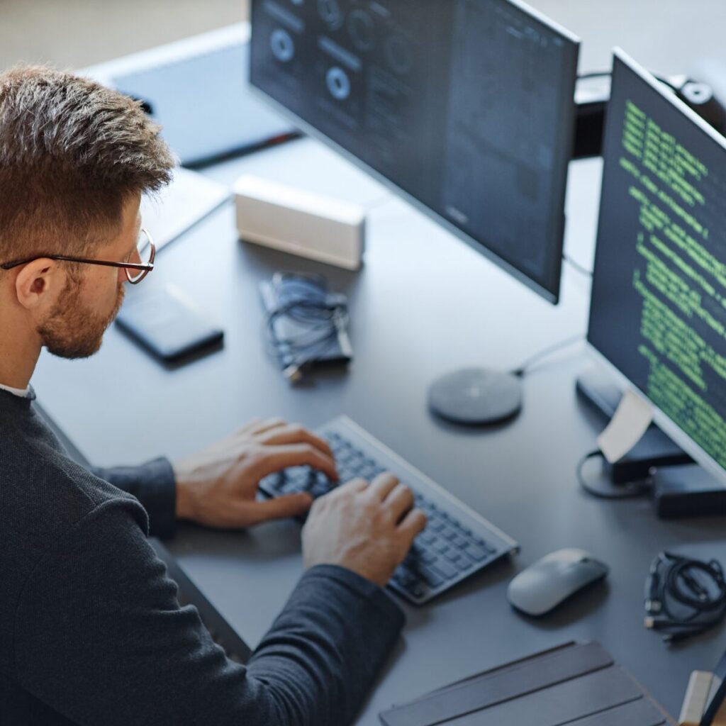 A developer writing code at a PC.